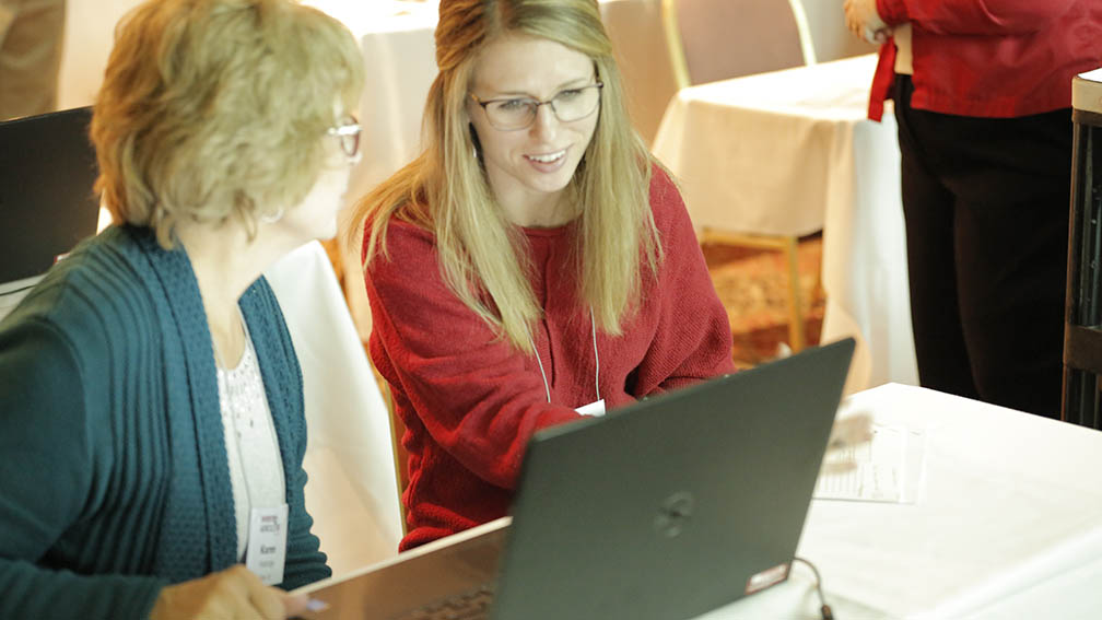 Two participants using a computer at the conference