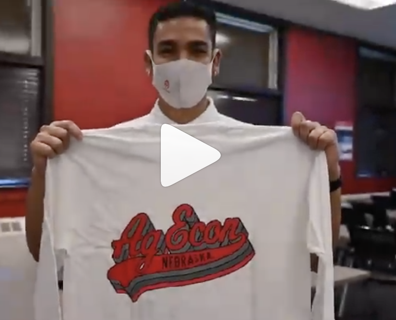 Screen cap of student holding Ag Econ shirt.
