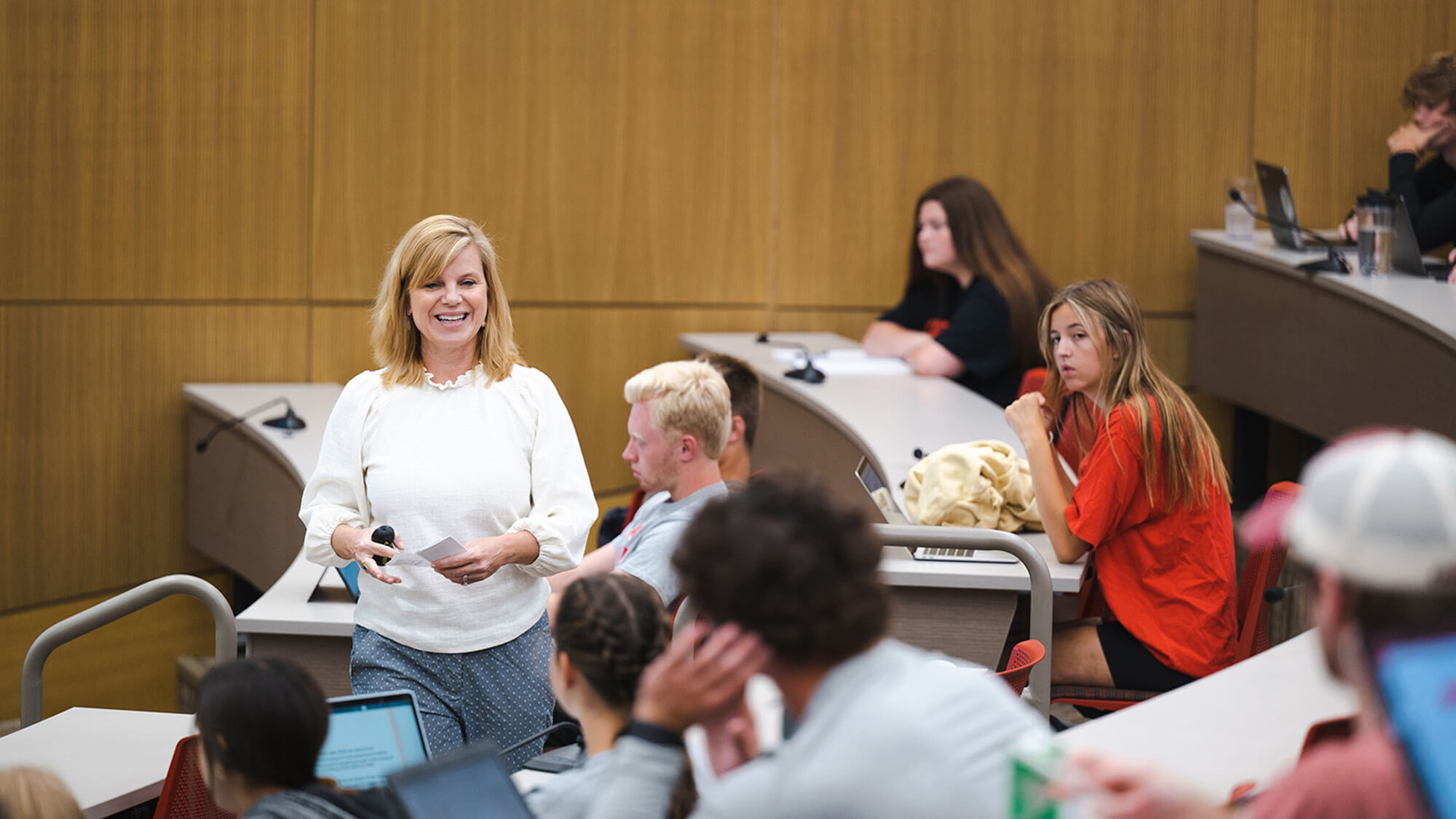 Faculty member walking through classroom talking with students